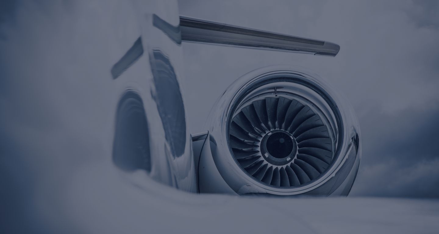 An aircraft turbine with clouds in the back